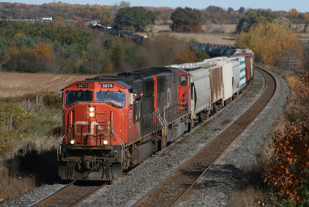 CN 305\'s conductor gives a wave as they roll by