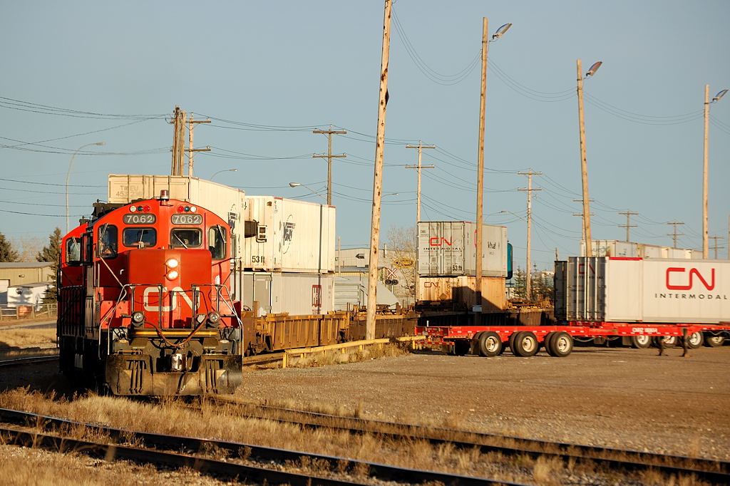 CN GP9RM\'s 7062 and CN 7077 switch intermodal cars in the late evening November sun at CN\'s Sarcee Yard in Calgary, Alberta.