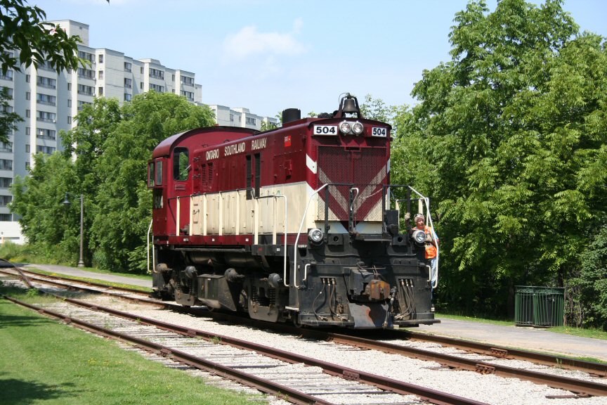 Ontario Southland (OSRX) RS23 504 backs up to couple onto its train after setting out an old wooden caboose owned by the local historical society on a rarely used spur in downtown Guelph.