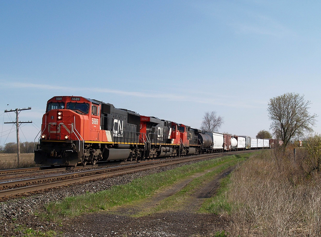 CN 385 with CN 5689 - CN 2242 - CN 2579 and 98 cars are coming around the big sweeping curve at Powerline Road that leads up to the bridge over Fairchilds Creek.