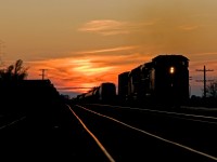 An eastbound manifest charges out of the sunset in Paris, Ontario.