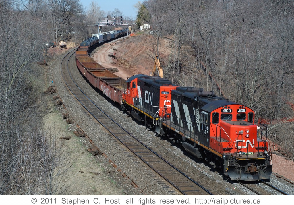 A CN Westbound departing Aldershot yard for Hamilton Yard with CN 4108 and 4018 and a decent size train. The GO TRIP third main track construction had recently begun and you can see grading in progress.