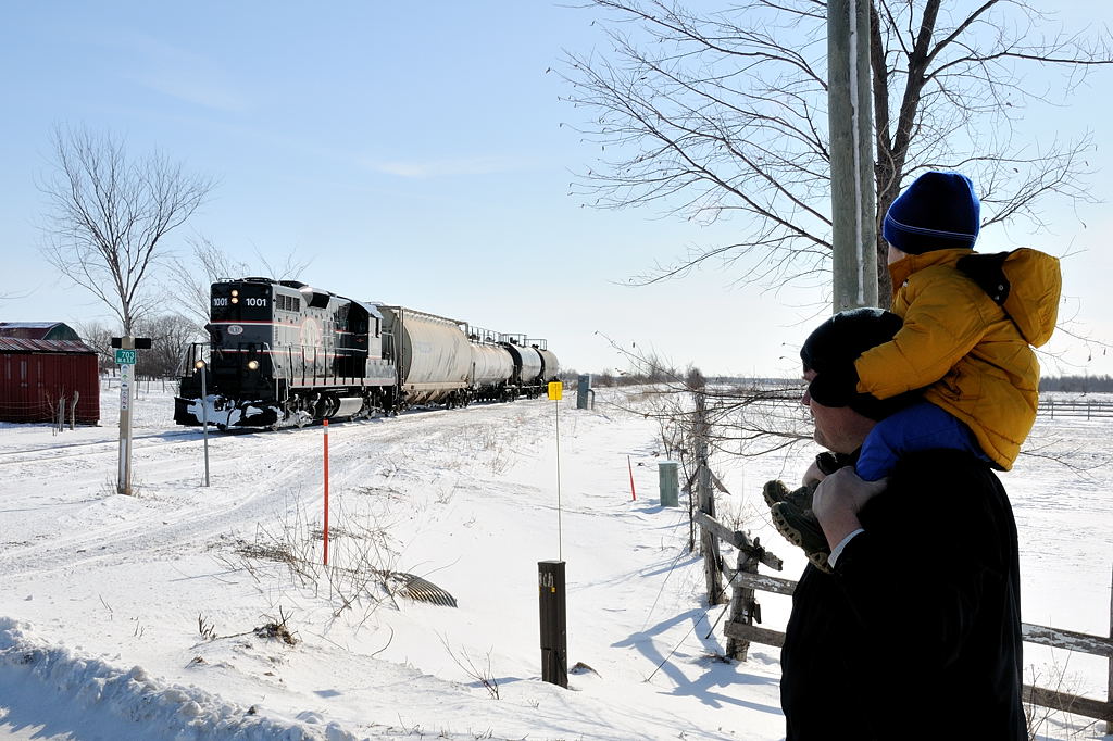 Rare encounters. The magical romance of a rickety branchline. In the middle of Simcoe County, a father and son stand at a rural crossing between Stayner and Collingwood as high nose GP9 CCGX 1001 lumbers its four car train along the Meaford Spur approaching the small rural hamlet of Batteaux. Due to dwindling traffic this portion of the Meaford Spur west Utopia to Collingwood will be abandoned by year end.