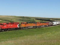 CP 878 or BNSF C-SCMMIB with 6067 and BNSF run-through power lead a 156 car coal train bound for Brandon snakes through the valley at Oxbow Sk.