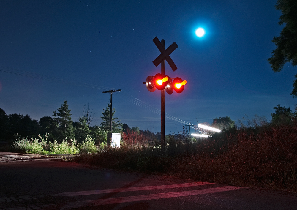 It\'s 41 minutes past midnight on a quiet clear night in Bolton, the multiple blasts of the horn from a Canadian tuned Nathan K3LR2 compliment the chugging FDL\'s of three AC4400\'s in the night sky. The crossing activates, the right of way lights up its show time.