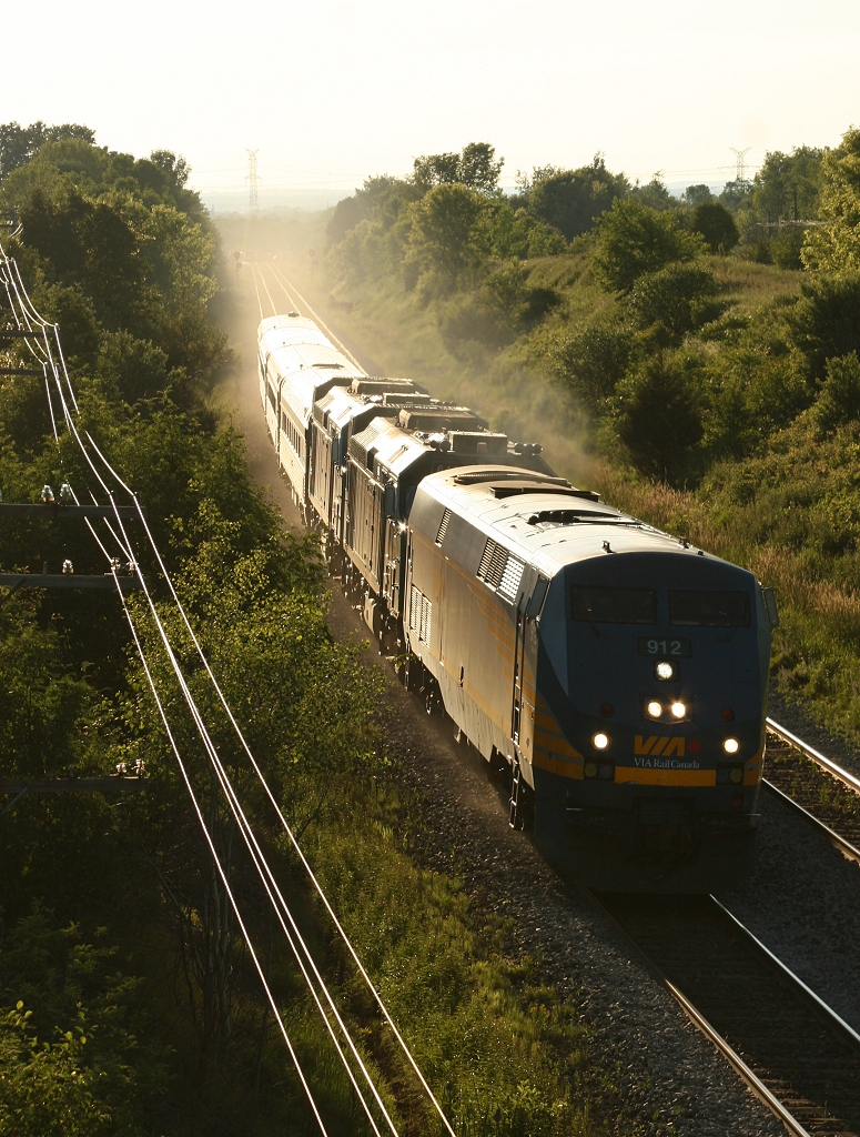 Montreal bound VIA 68 kicks up dust on freshly dumped ballast as it rolls out of the sunset with VIA 912, VIA 6432, VIA 6442 and 4 coaches.