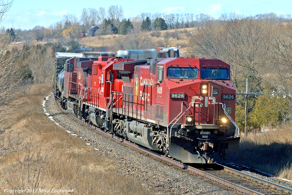 CP 9626, 3032, and 9571 lead 234\'s train through the s-curve at Newtonville. The 3032, seemingly fresh out of the shop and in new paint, has the dubious distinction of powering the last CP train out of Goderich, Ontario. 1220hrs.
