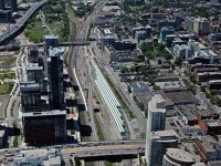 1,300 ft high (while offering a beautiful view of the city) above on the observation deck of the CN Tower, an inbound GO train makes it\'s way into the downtown core of the city.
