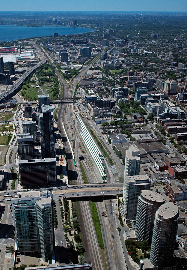 1,300 ft high (while offering a beautiful view of the city) above on the observation deck of the CN Tower, an inbound GO train makes it\'s way into the downtown core of the city.