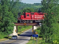The Conductor of T07 gives a friendly gesture as they pass over the bridge in Cavan Ontario.