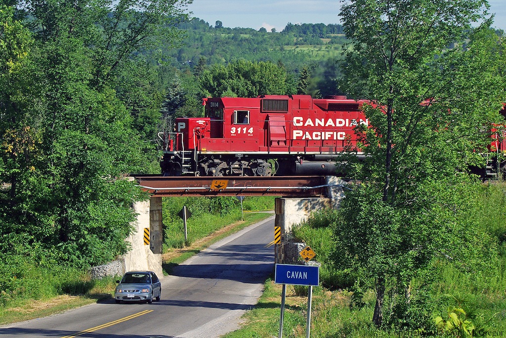 The Conductor of T07 gives a friendly gesture as they pass over the bridge in Cavan Ontario.