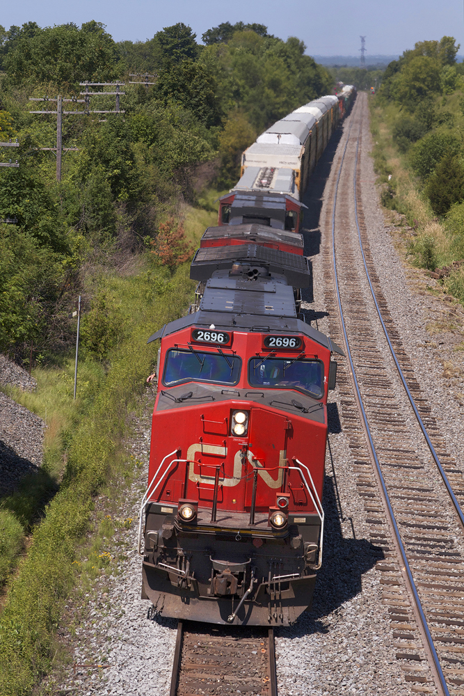 CN C44-9W 2696 leads M30831 09 past the bridge at Lovekin with some Nathan P5 horn for the foamers.