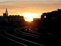 As the sunsets on another beautiful West Coast day, CP GP9u 1623 is silhouetted, as it pulls forward with a string of grain hoppers it is switching around the Port of Vancouver.