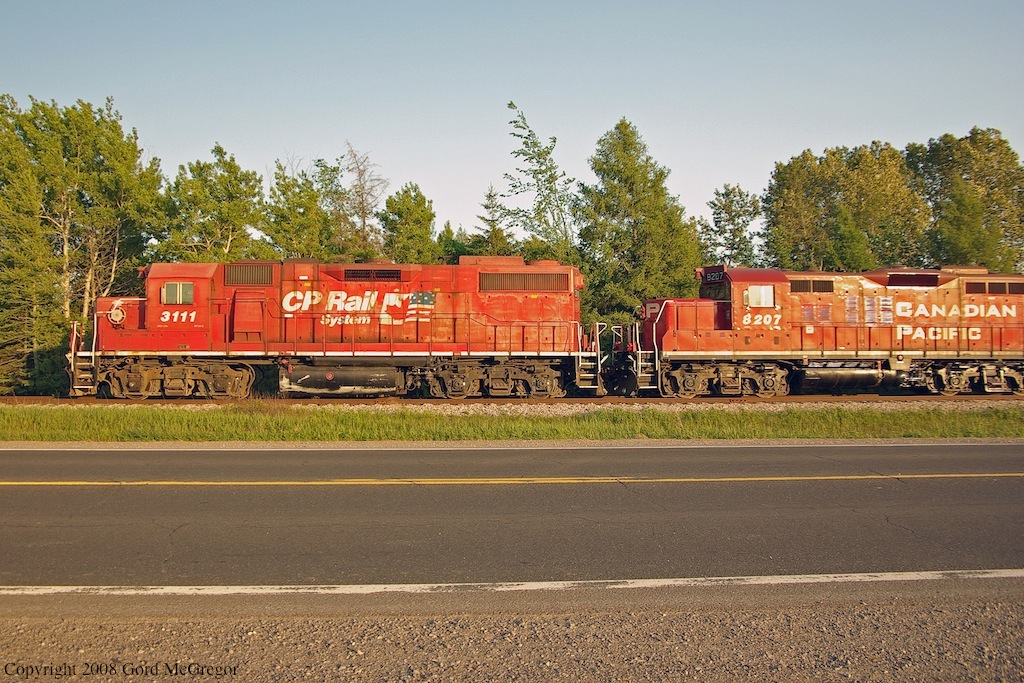 3111 with the dual flag scheme and 8207 lead T08 into the setting sun outside Havelock Ontario.