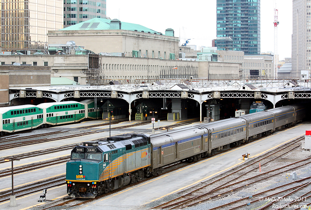 Rebuilt VIA F40PH-2 6449 leads a set of Budd-build HEP cars out from under the train shed on train #75. In the background is the grey \"headhouse\" of the 1920\'s-era Toronto Union Station, the tall rectangular part of which houses the famed Great Hall.