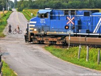 As a pair of locals watch, CEFX 1014 pulls through the siding at Lovekin with 143\'s train as an eastbound bears down on them. 1803hrs.