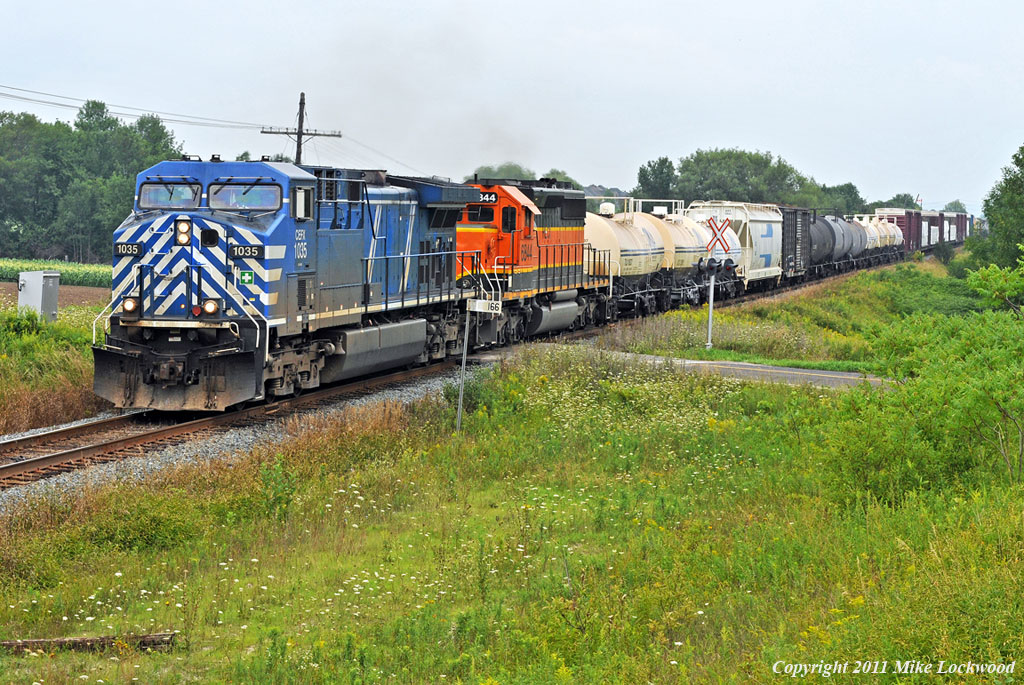 A blueberry and a pumpkin lead 235\'s train past MP 166 of the Belleville Sub. CEFX 1035 and HLCX 6844. 1330hrs.