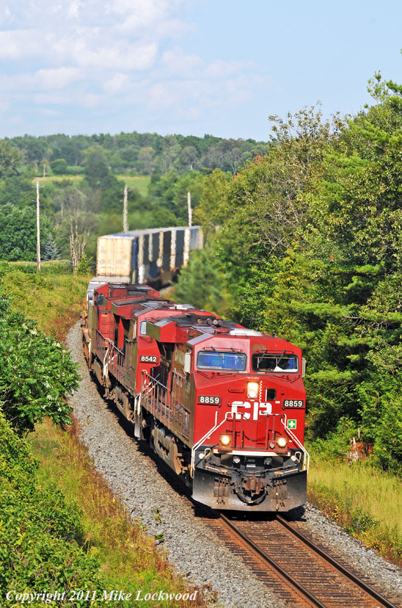CP 8859, 8542, and 8557 race west with 115 just past the western Port Hope mileboard. 1718hrs.