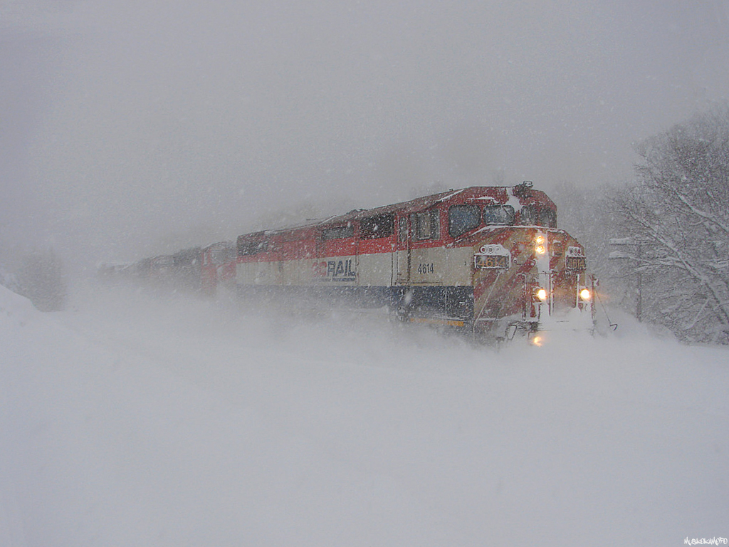 CN A45031 10 - BCOL 4614 South charging through the snow in full force with a crew member in each locomotive ready to isolate/cut in as needed trying to bring their large train down the hill then back up again heading South out of town. Back there somewhere are CN 5303, CN 5348 and CN 4136!
