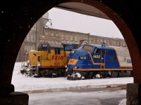 Strong snow squalls that  pounded the Kitchener-Waterloo area let up as light power (FP9 RLK 1400 with GEXR 3821 out of frame) framed by the VIA station arches, head west after rescuing 584's train up in Elmira on the Waterloo Spur. In the background power for GEXR 433 [Kitchener to London turn] readies for it's day's duties.