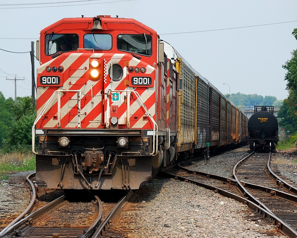 CP 441 with a pair of red barns shoves a long cut of empty autoracks into Coakly siding for the OSR to pick up.