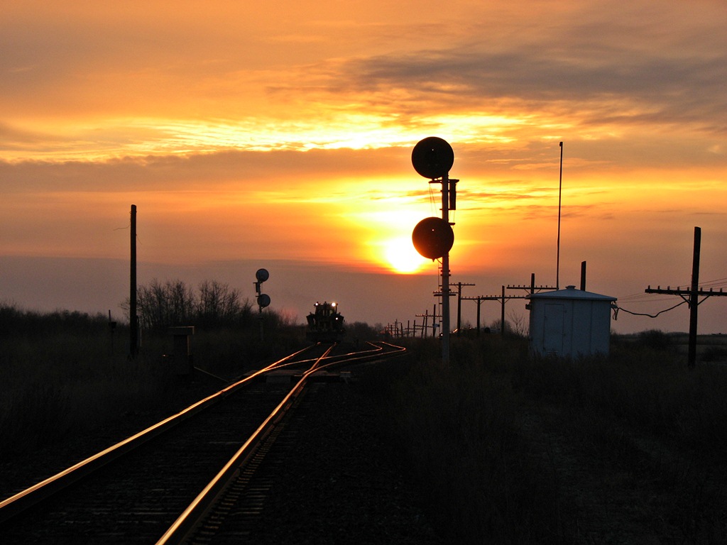 Ballast regulator works on the siding at Rotave during a beautiful sunrise.