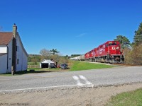 A man out doing some yard work pauses to watch T08 pass by with 40 cars on Mothers Day 2011