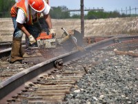 A switch building gang working on the elevator switch in Moosomin.  This worker fires up the rail saw and cuts it down to fit the rail in the joint. I am now more familiar to doing track installation at Cando Contracting.