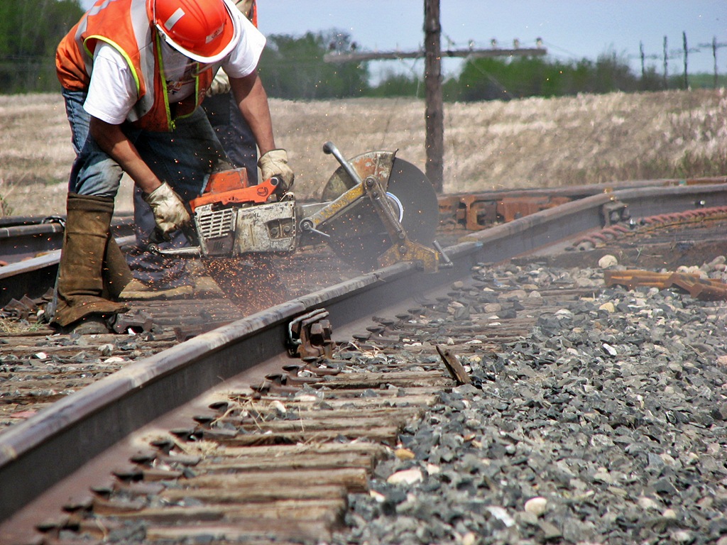 A switch building gang working on the elevator switch in Moosomin.  This worker fires up the rail saw and cuts it down to fit the rail in the joint. I am now more familiar to doing track installation at Cando Contracting.
