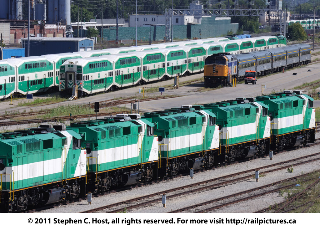 A row of stored GO F59\'s (10 in total, only 5 pictured) sit stored, numbers blanked out, reportedly sold to AMT for commuter service in Montreal and are awaiting transfer. In the background is VIA and GO equipment laying over after the morning commuter rush.