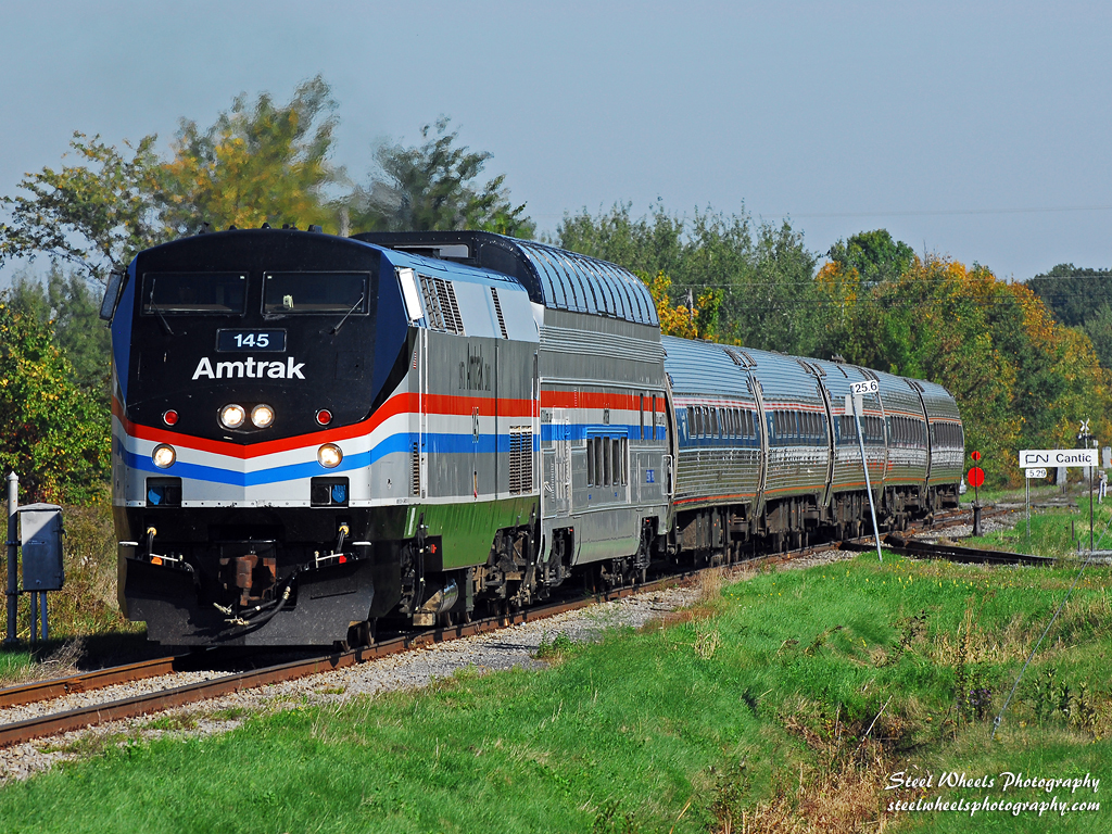 The annual fall foliage dome car addition to the Amtrak Adirondack train was complimented this year by its arrival in the Phase III paint. Amtrak also assigned the Phase III P42DC 145 to the Adirondack service to be mated with the dome car runs. On September 27, the Amtrak Adirondack train 68 is seen rolling south through Cantic, Quebec on Canadian National\'s Rouses Point Subdivision as it passes the switch to the CN Swanton Sub in splendid morning sun. Many more photos at http://steelwheelsphotography.com.