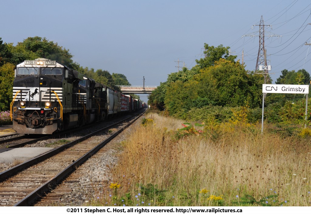 CN F328, a Norfolk Southern (CN Haulage agreement) detour train is remenicent of NS 328 of years past as it rolls by the Grimsby VIA station