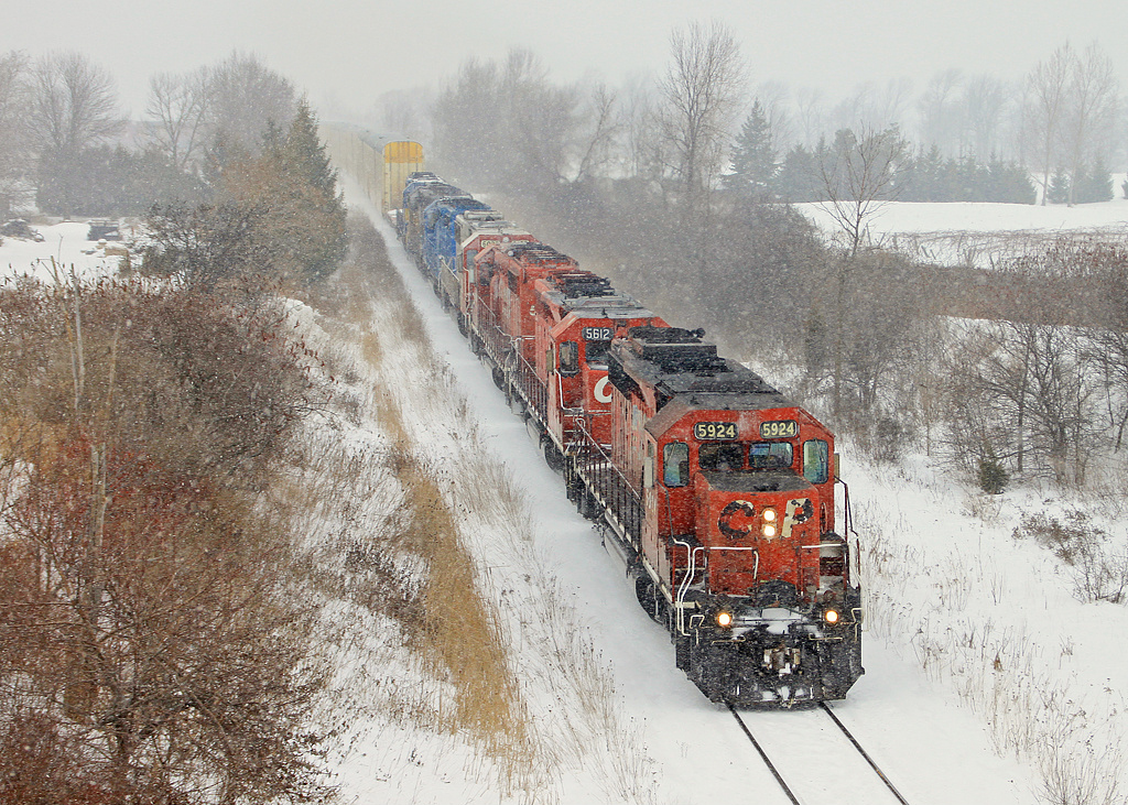 CP 5924 crests the Niagara Escarpment with the help of six other units during heavy snowfall. The leading three SD40-2s were taken from 446s train and tacked onto the front of 246-04.