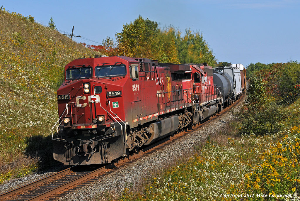 Nearing the crest of the climb west out of Port Hope, CP 8519 and DME 6096 have 235\'s train well in hand at Wesleyville. 1314hrs.