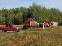 A red truck speeds infront of CN 5279-CN 238-CN 7258 as they click along the old Abitibi Mill spur located off the CN Mission Spur in Thunder Bay, ON. Pieces of the old Abitibi Mill at the end of the spur is being demolished and hauled out via rail in old wood chip gons and (regular) gondolas.