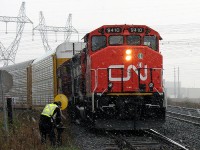 Waiting at the busy Torbram Rd crossing in the falling snow, CN 9410 with still-fresh zebra paint leads 577, the CN-CP Lambton transfer run, as it waits to enter Malport Yard. After the conductor trainee tends to the switch, 577 will proceed into Malton with its interchange cars from CP.