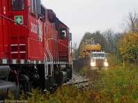  T07 has a rare meet with a loaded hi-rail truck as the crew waits on the siding.