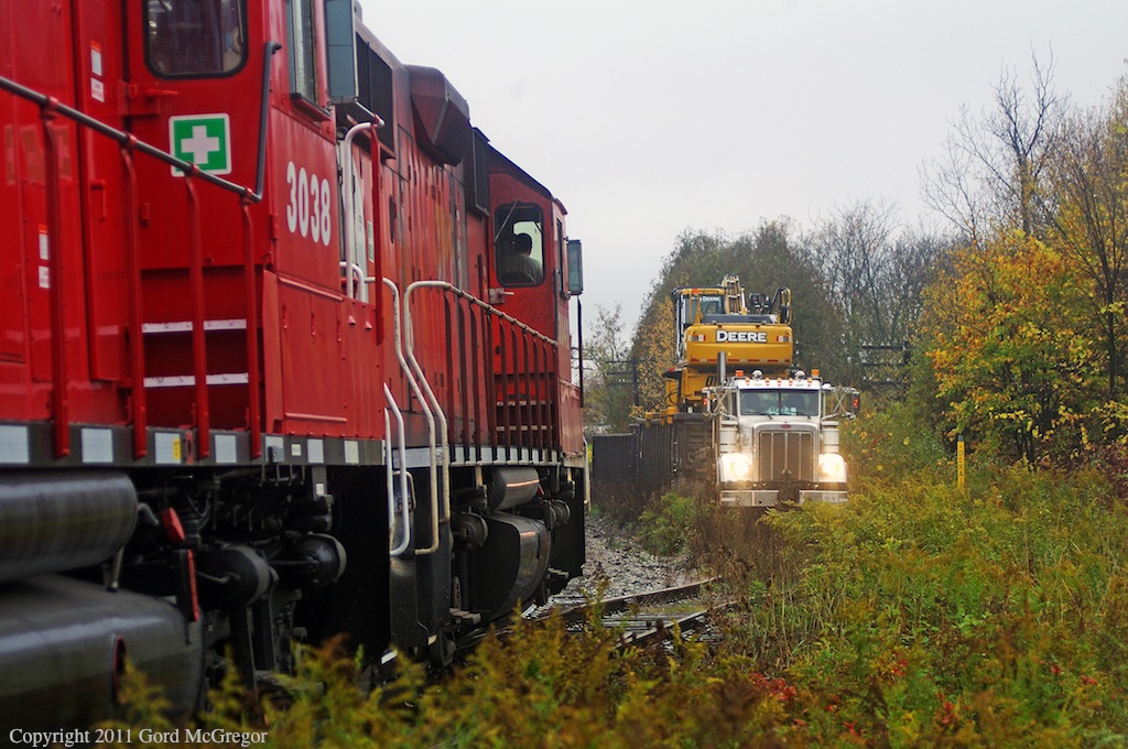 T07 has a rare meet with a loaded hi-rail truck as the crew waits on the siding.