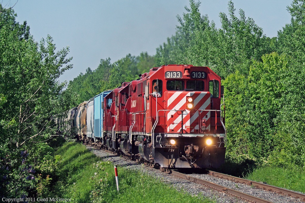 Climbing up the grade on a very tight section of the Sub at Duffins Creek,3133 is leading the longest train of the year 62 cars.The old Soo labelled cars used for many years are being replaced by CEFX  and others and a stock pile was needed.