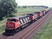 Four MLW M-420s drift down grade to towards Clarke and are about to pass under the Lakeshore Road bridge adjacent to CP's Lovekin siding in July 1995