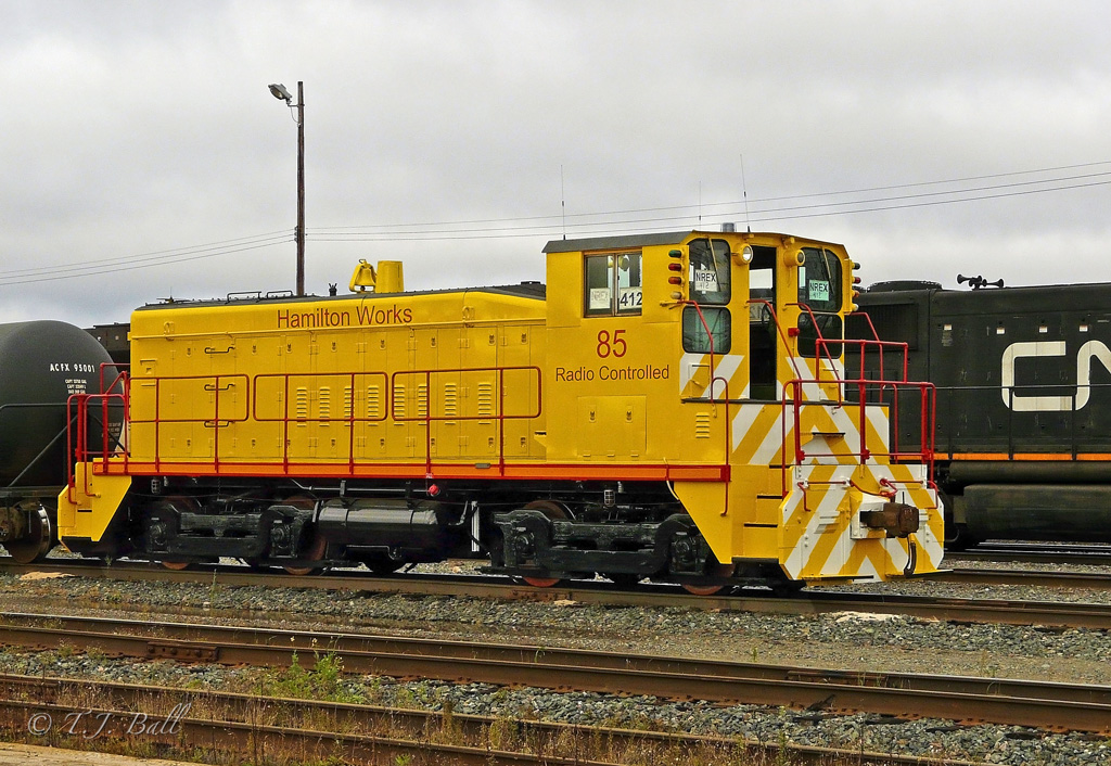 Fresh from the NRE Shops in Capreol, Hamilton Works 85 sits on the south lift at Capreol.  594/596\'s power sits behind it.  Unit had come out of Nanticoke, Ont. and was in Capreol for a rebuild.