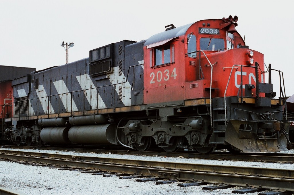 CN seventies super power at MacMillan Yard, Toronto awaiting next assignment: MLW C-630M 2034  is paired with MLW M-636 2305 . Spring 1977 Kodak Kodacolor II ASA100  negative transported by a Nikon Nikkormat EL. Photographer S. Danko.