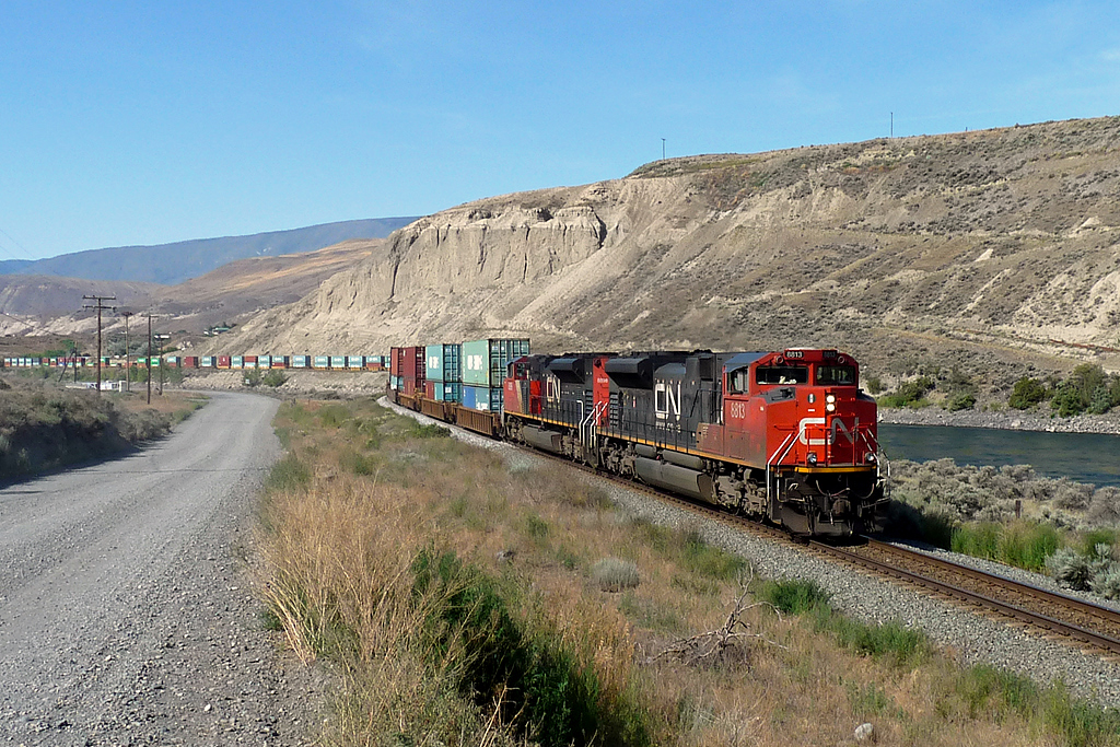 SD70M-2s 8813 and 8898 depart from Ashcroft as they lead an eastbound intermodal over the Thompson River.