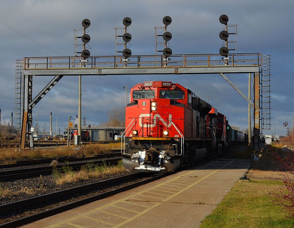 CN 148 led by CN 8859, 2225, 2702 & IC 1010 passes the signal bridge at the Sarnia VIA platforn after coming thru the tunnel from Port Huron.