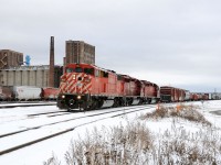 CP 9012 East, 420-26 has finally been given the okay into the terminal after holding clear at the airport for more than an hour. Initially the crew was to pull down through the yard (in the background) and cut of their tailend portion, but due to heavy congestion with a yard crew setting a "box" train (local CP slang for grain empties), the box train crew looking to get onto it's freshly built consist, empties fresh from the "Mission" elevators and the "Resolute" (paper mill) job looking to get out to the mill, along with a few through mainline freights the crew had to wait their turn. Now with a route the crew pull down to the "Bottom end of C-yard" to make their setoff, passing Western Grain in Westfort. Power: CP SD40-2F 9012- CP SD40-2 6602- STLH SD40-2 5651.