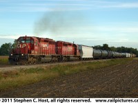 CSXT D725, using Run-Through CP Power is heading south through Port Lambton, Ontario on the Sarnia Subdivision with about 90 cars in tow from Sarnia's "Chemical Valley". This train will Interchange their cars in Chatham, Ontario today and return with a similar group of inbound cars. Today, this track is lucky to see a train a week and is very much overgrown with weeds as the line has been all but abandoned at this location.