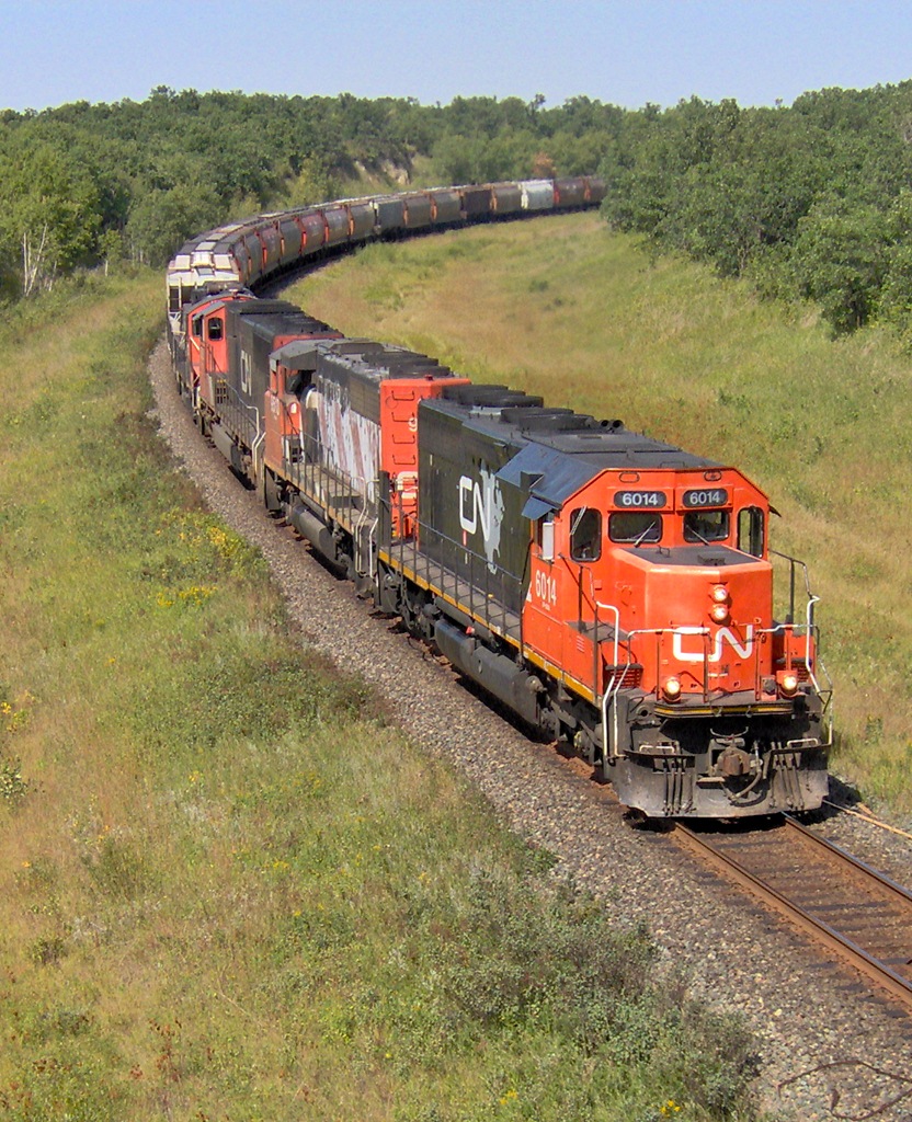 CN 6014 leads a manifest with military vehicles split in the middle along with a collection of emd power bound from Melville to Symington.