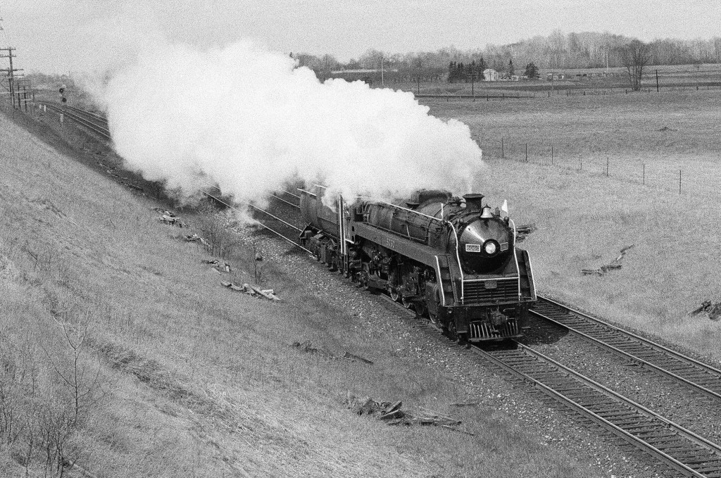 Imagine.   Just imagine, being at one of your favourite rail location(s)....  ......and believe you are up to speed on all the latest happenings....  .... then looking up at the horizon you see a white plume....  ......then you hear a whistle....what was that again?  ..... hear again....A REAL whistle.....  .....the kind you hear about in stories told to you by your Great Uncle.....   ......So 10:30 a.m., April 29, 1979,   ......at the ever popular Newtonville Road overpass Kingston Subdivison mile 280,   presenting   CN extra 6060 East..........  ......loafing along at a self imposed 45 m.p.h.......  .....Of course, what else is there to do but photograph active mainline steam on a dreary dull April Sunday?  April 29, 1979 Kodak Plus X Pan b&w negative film, ASA125, transported by a Nikon F2.   Photographer S.Danko.