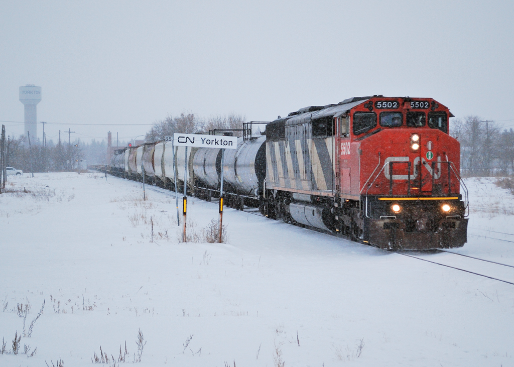 CN 5502 drags 47 cars of mostly empty flats across CP\'s Wynyard Sub as it makes its way north on the as needed CN Yorkton Sub to the HBRY.