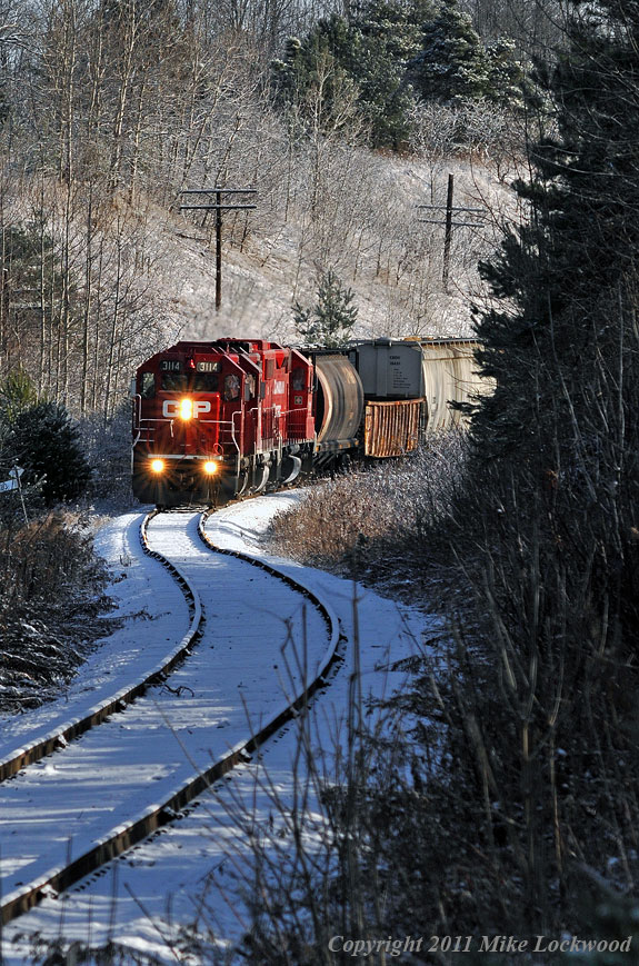 A light dusting of snow that fell overnight is barely disturbed by Kawartha Lakes T07 at Raglan. CP 3114, 3032, and 3111 lead 22 cars west. 1040hrs.